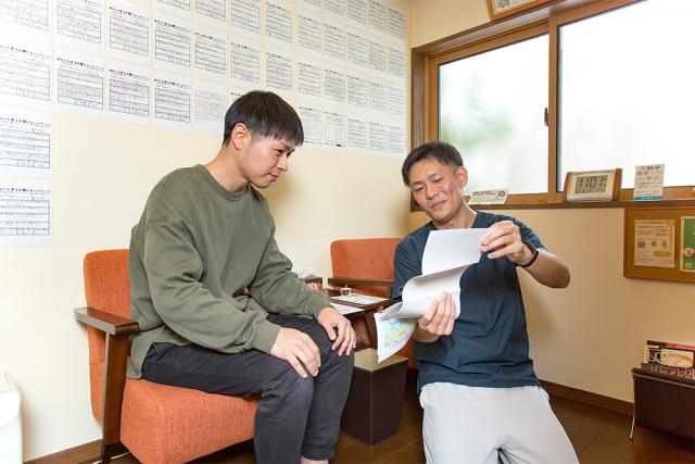 施術後の確認、アドバイスを行っている様子、男性患者様と院長が話している